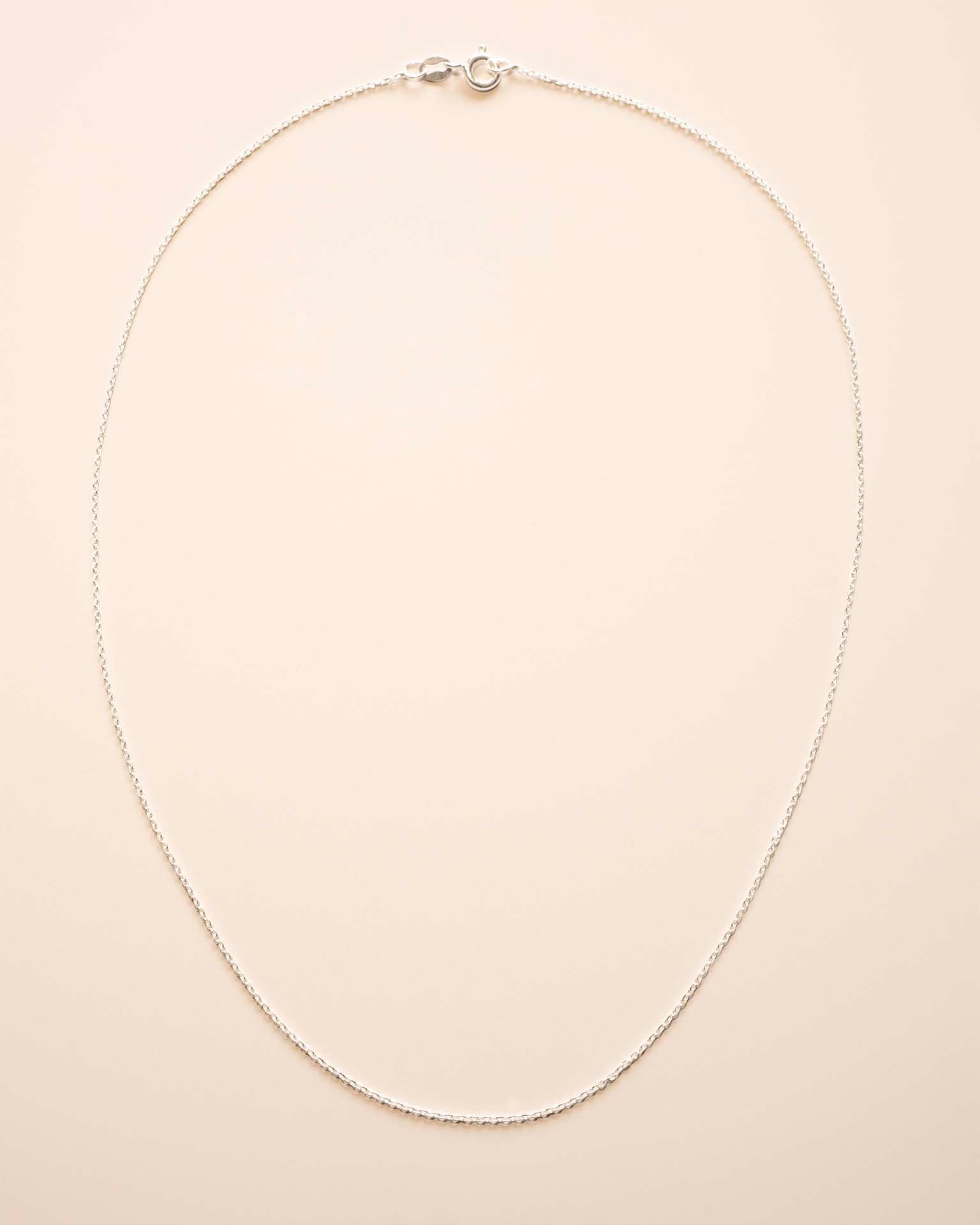 Silver necklace on a beige background