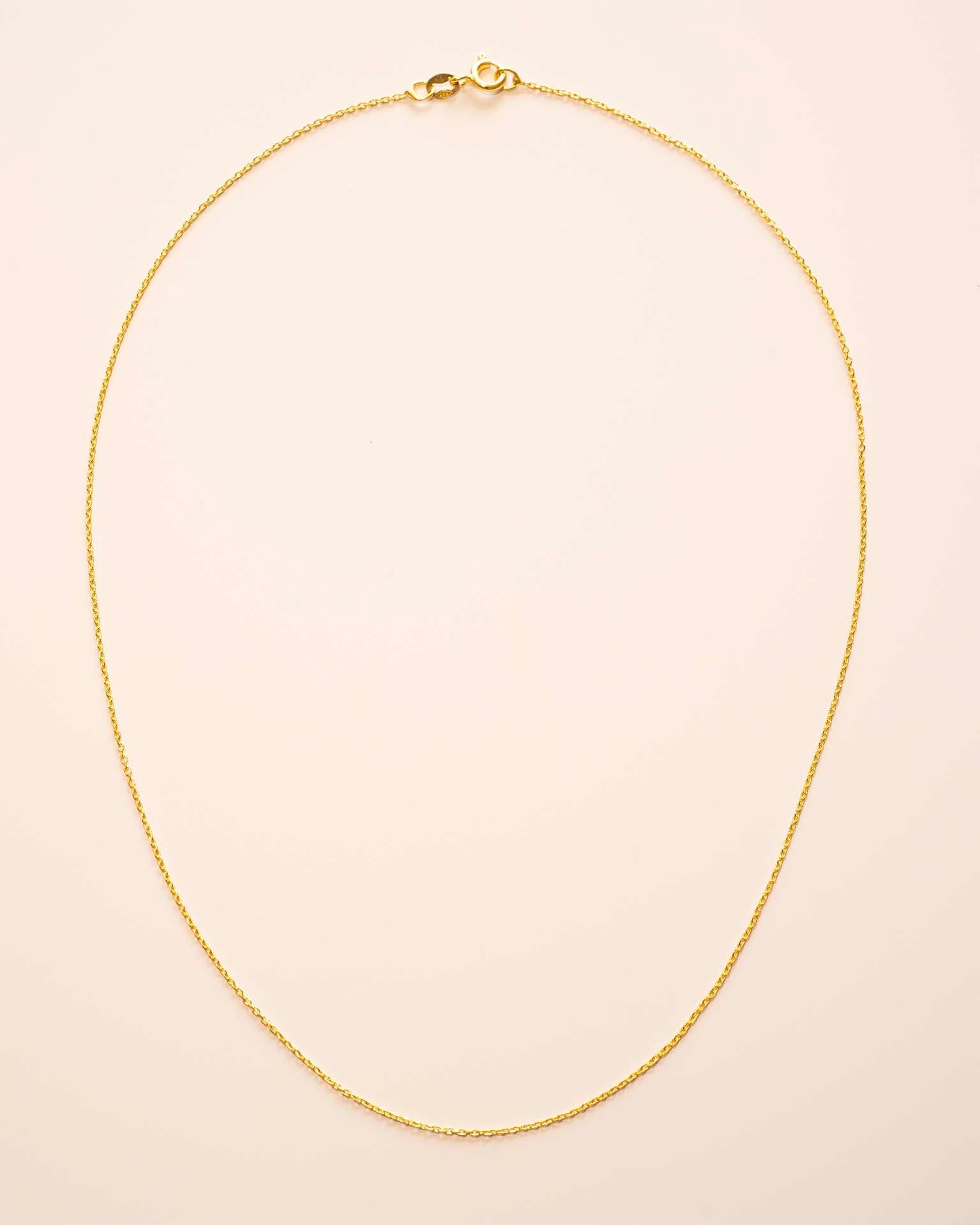 Gold necklace on a beige background
