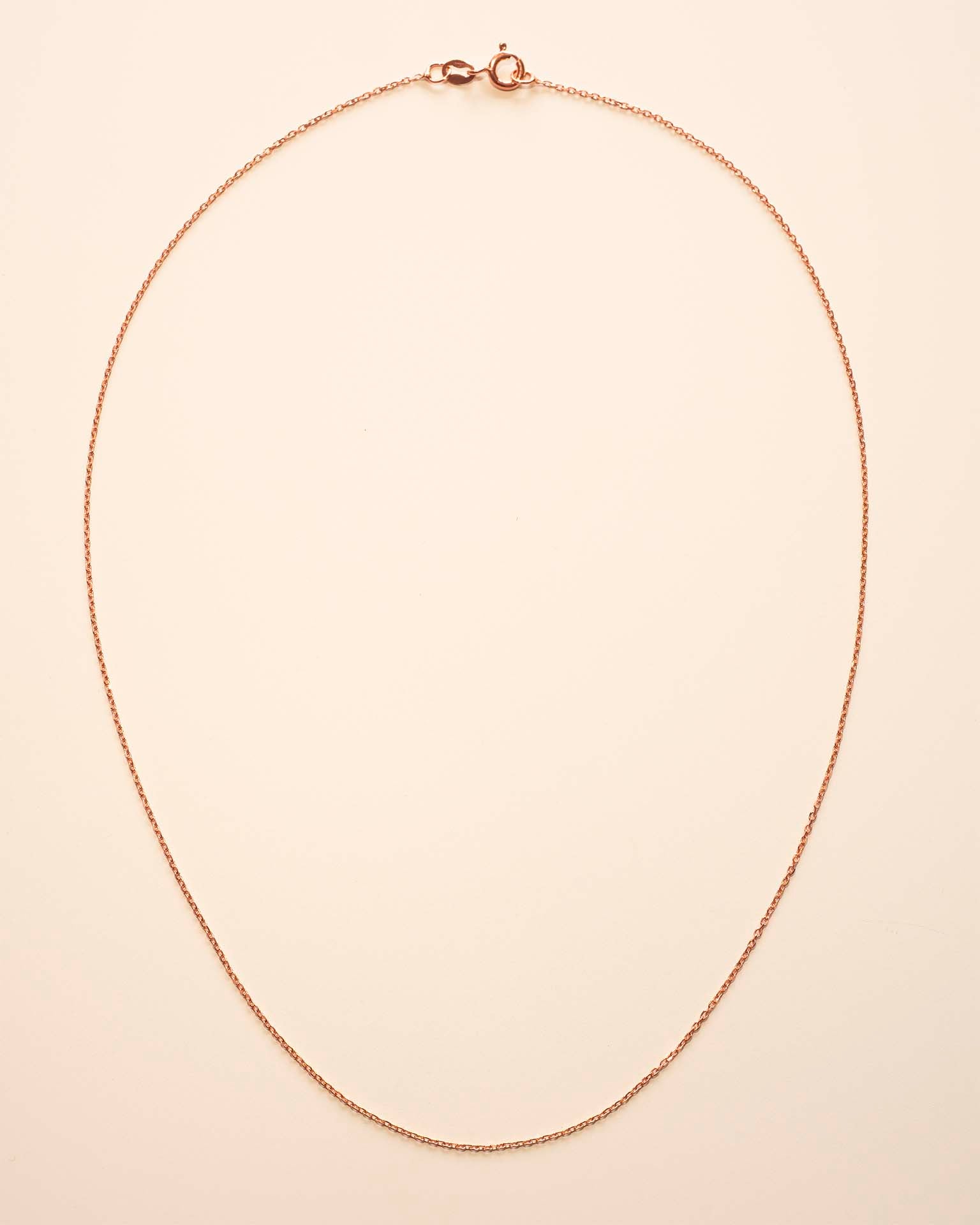 Gold necklace on a beige background