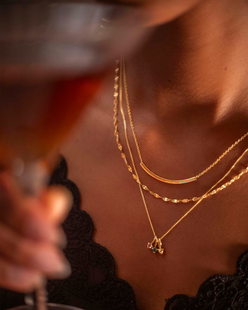Close-up of a person wearing gold necklaces with a blurred background