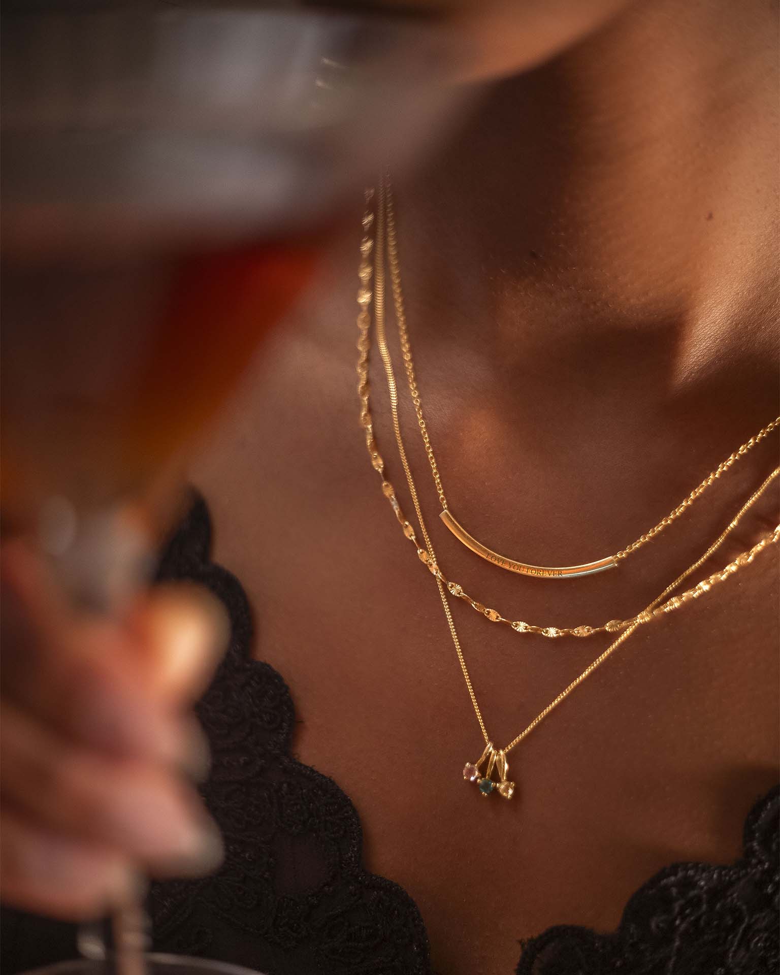 Close-up of a person wearing gold necklaces with a blurred background