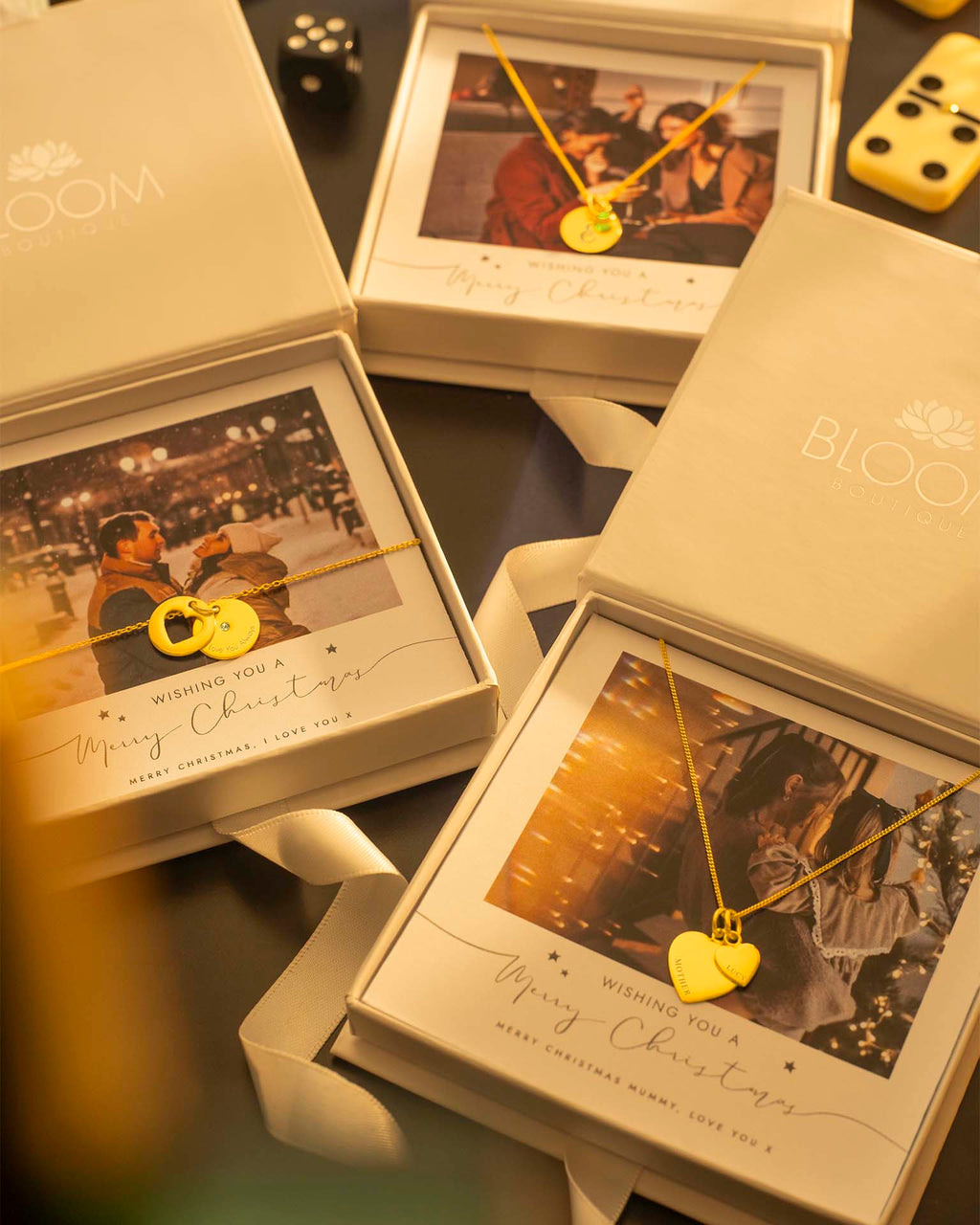 Gold necklaces with heart and lock designs in 'Bloom' branded boxes.