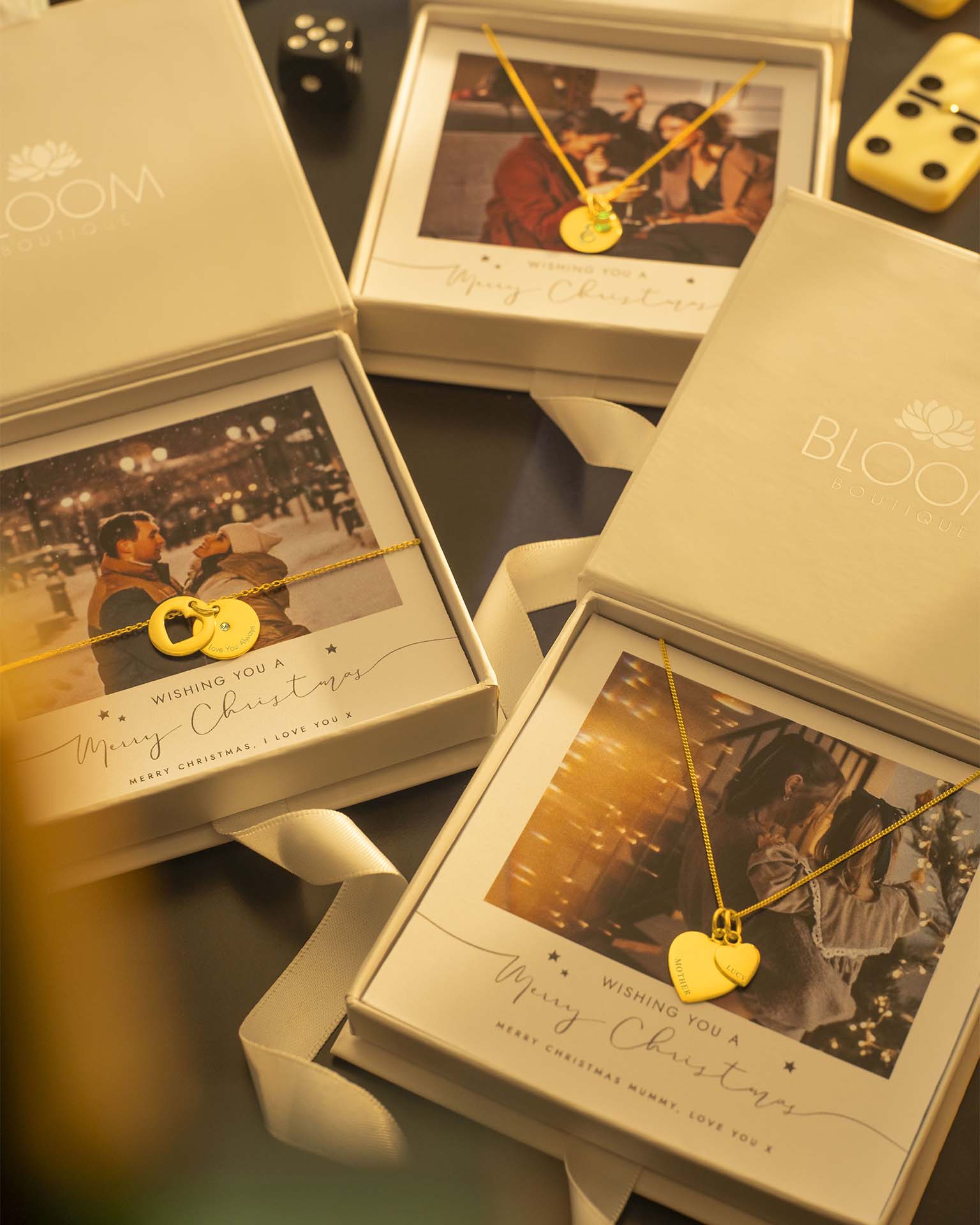 Gold necklaces with heart and lock designs in 'Bloom' branded boxes.