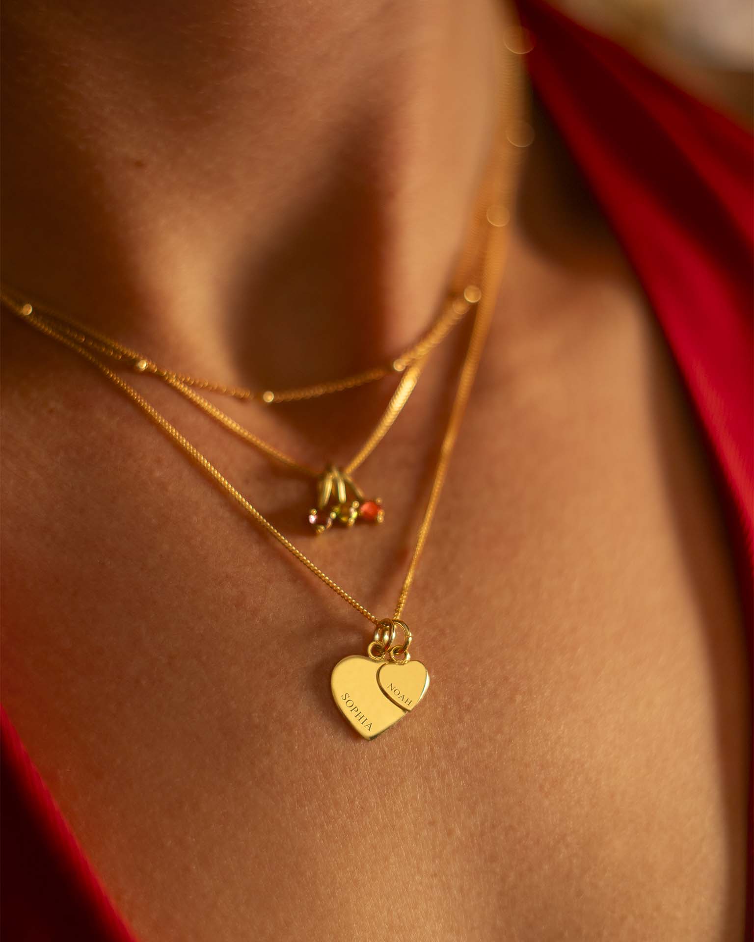 Close-up of a person wearing gold necklaces with heart pendants. | Christmas