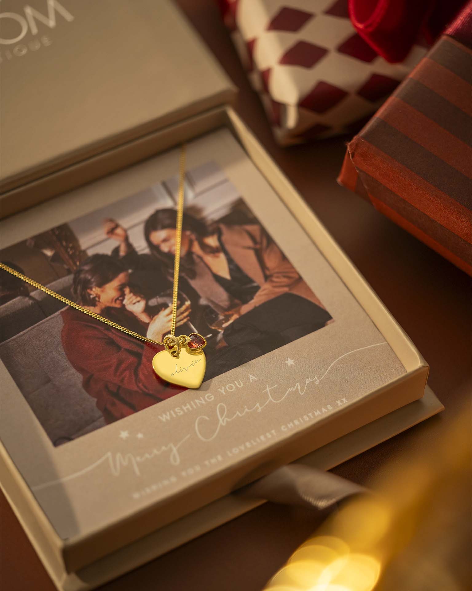 Gold heart-shaped necklace in a Christmas gift box with a photo of a couple | Christmas
