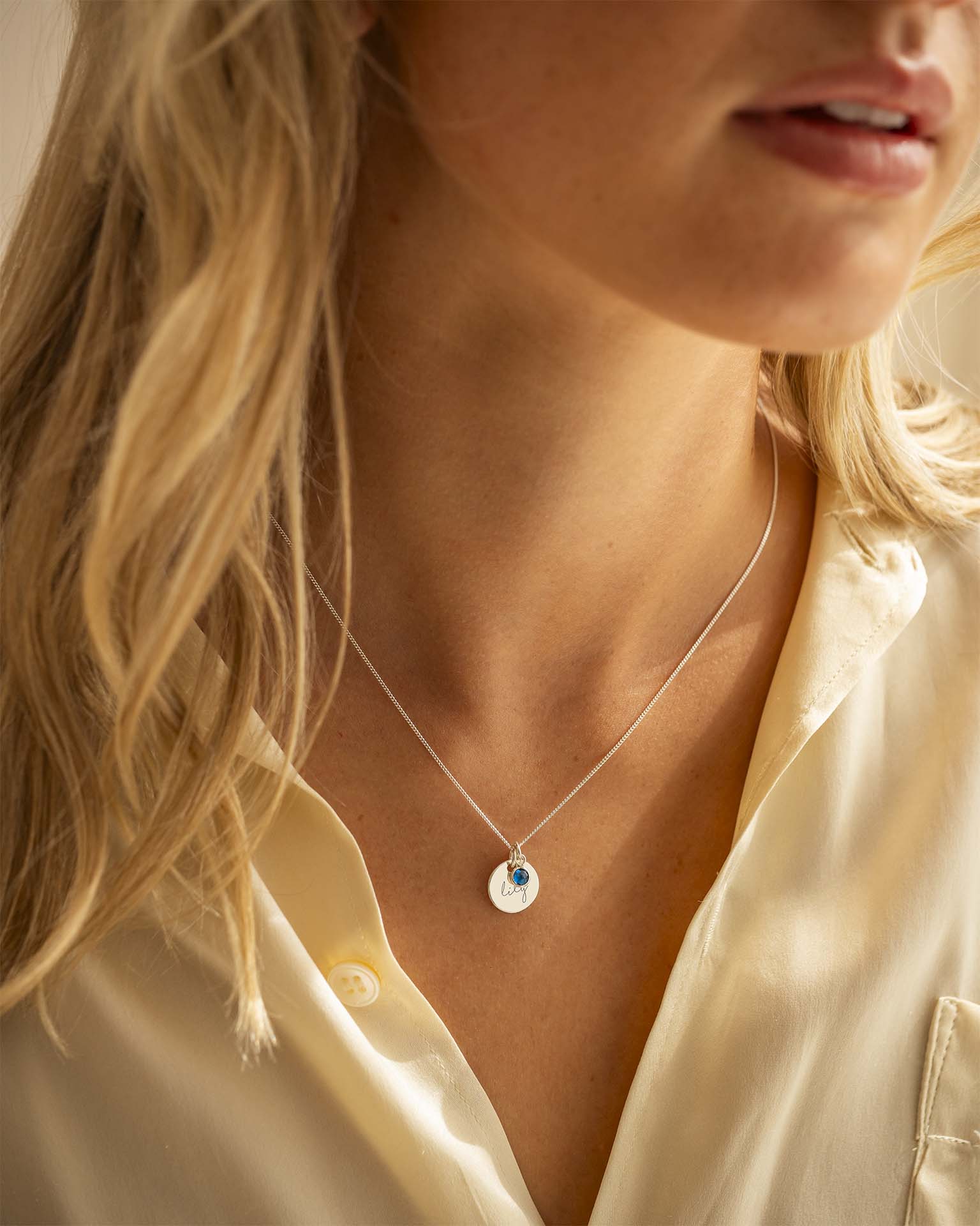 Close-up of a person wearing a delicate necklace with a small pendant.
