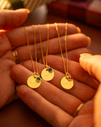 Gold necklaces with gemstones held in a hand