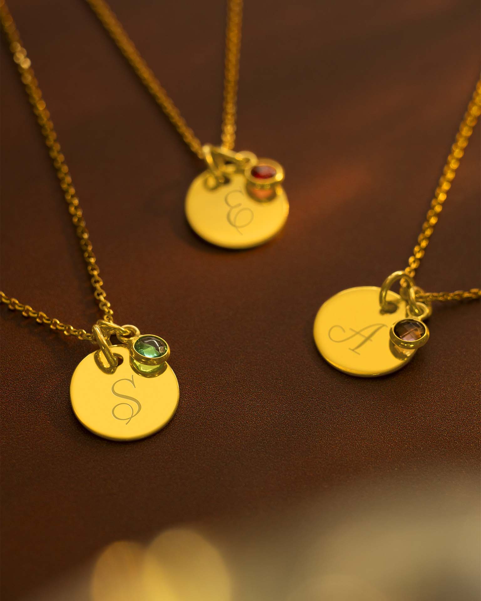 Two gold necklaces with round pendants on a brown background | Christmas
