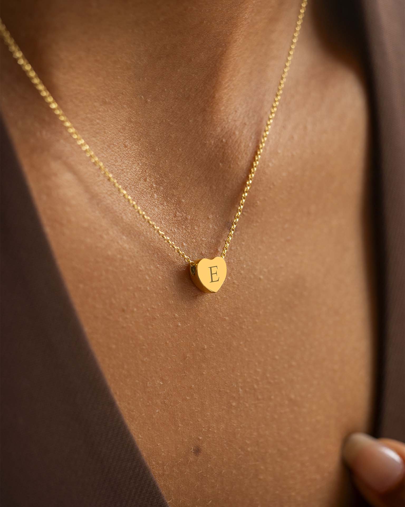 Heart necklace on model with brown top. | Christmas