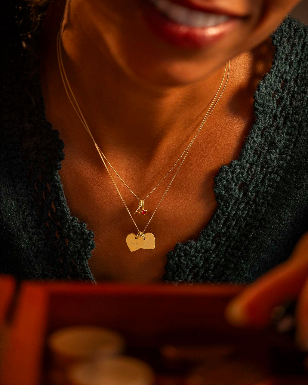 Close-up of a person wearing a necklace with a heart-shaped pendant.