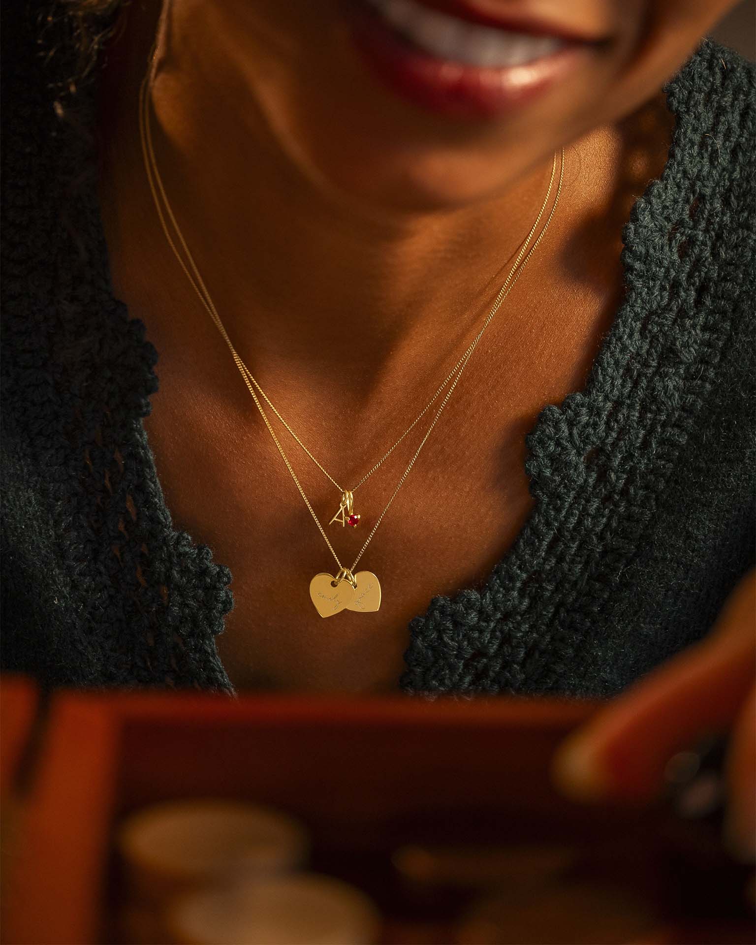 Close-up of a person wearing a necklace with a heart-shaped pendant.