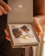 Gold necklace in a Bloom Boutique box held by a person