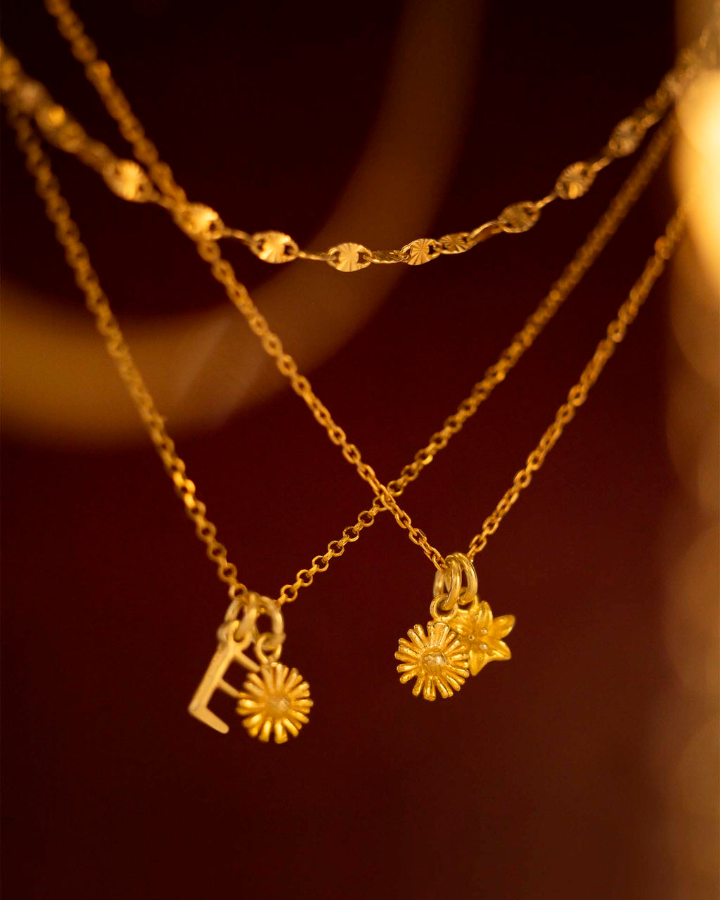 Two gold necklaces with sunflower pendants on a dark background | Christmas