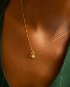 Gold necklace with a star pendant on a person's neck. | Christmas