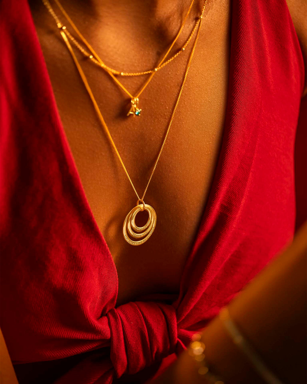 Gold necklaces with circular pendants on a red garment