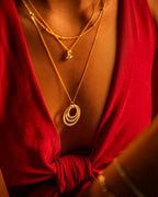 Gold necklaces with circular pendants on a red garment