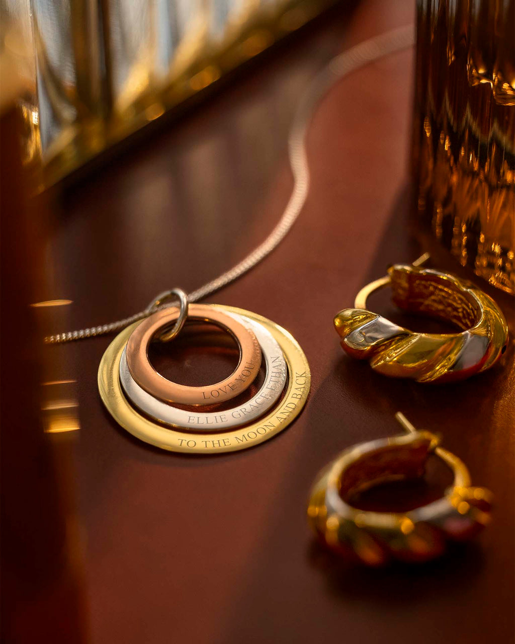 Gold necklace and earrings on a reflective surface