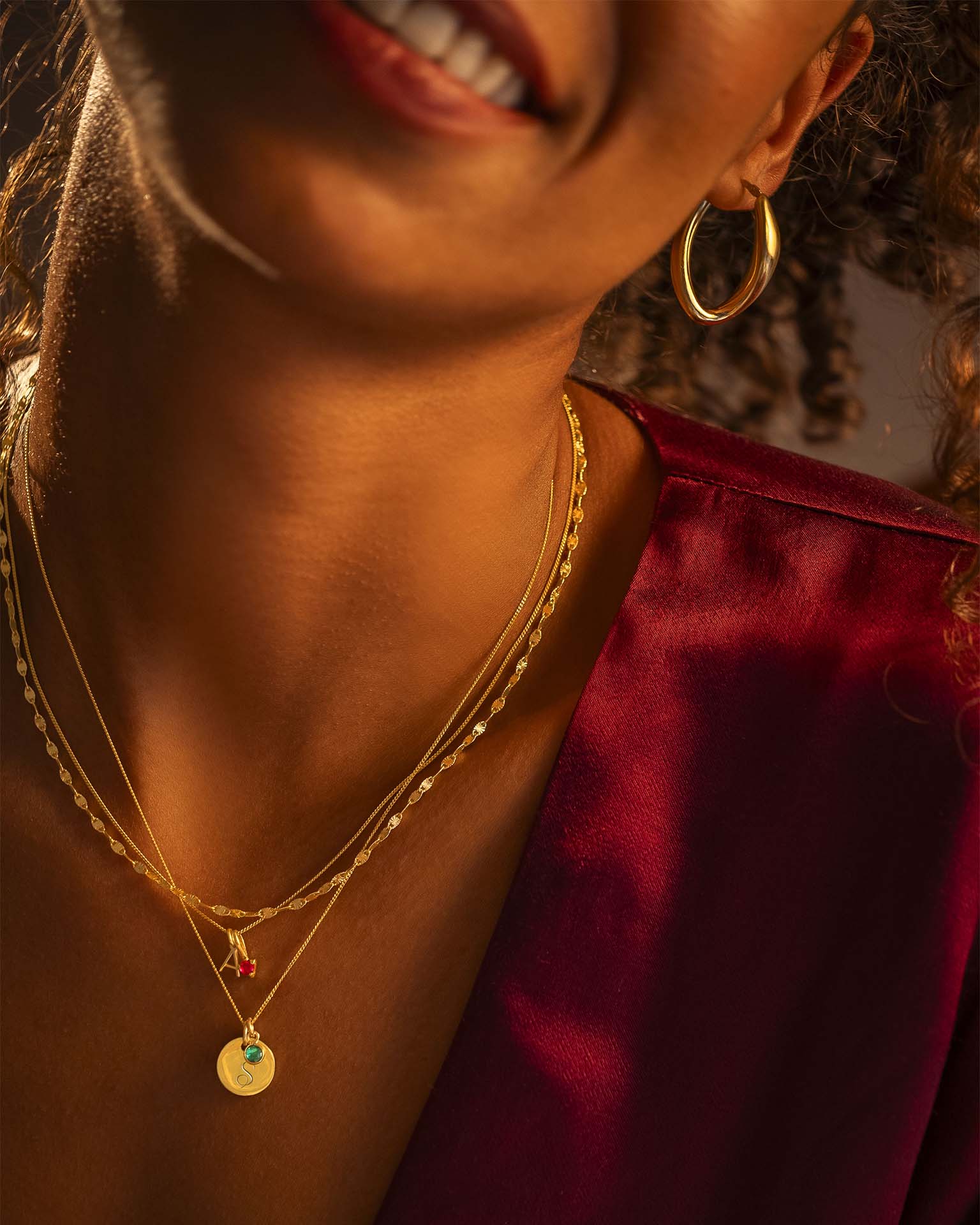 Close-up of a person wearing gold jewelry with a blurred background
