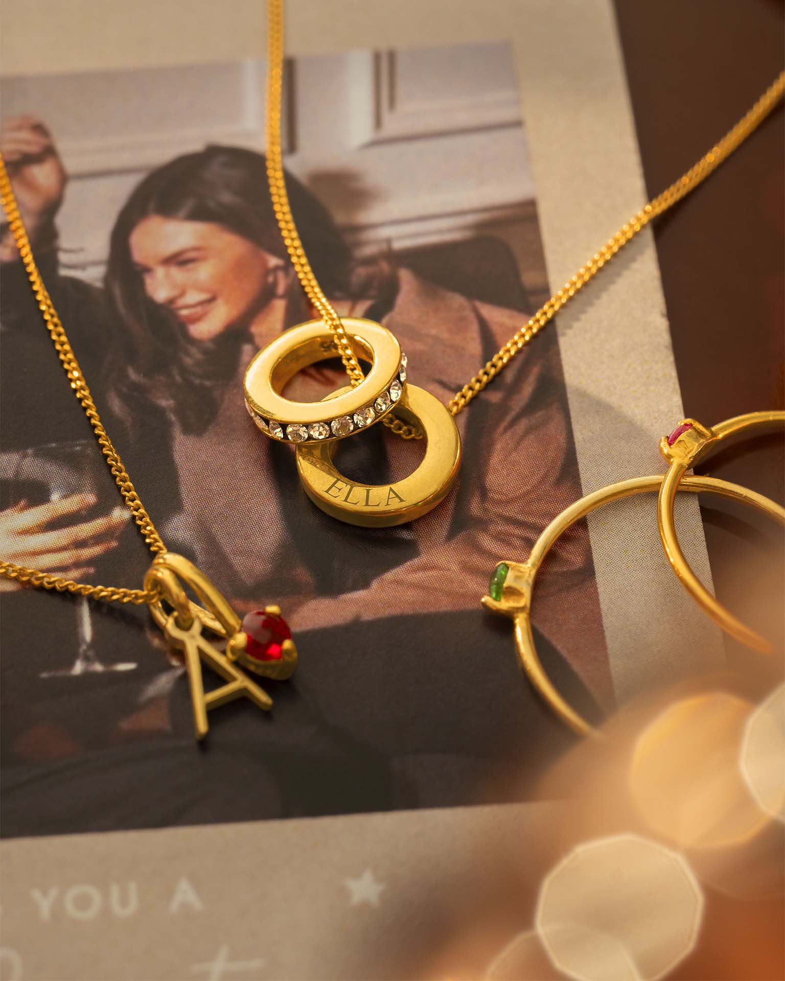 Gold jewelry with charms on a surface with a blurred background