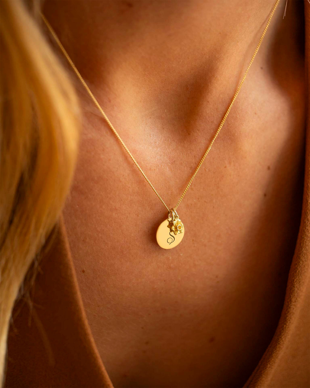 Gold necklace with a pendant on a person's neck. | Christmas