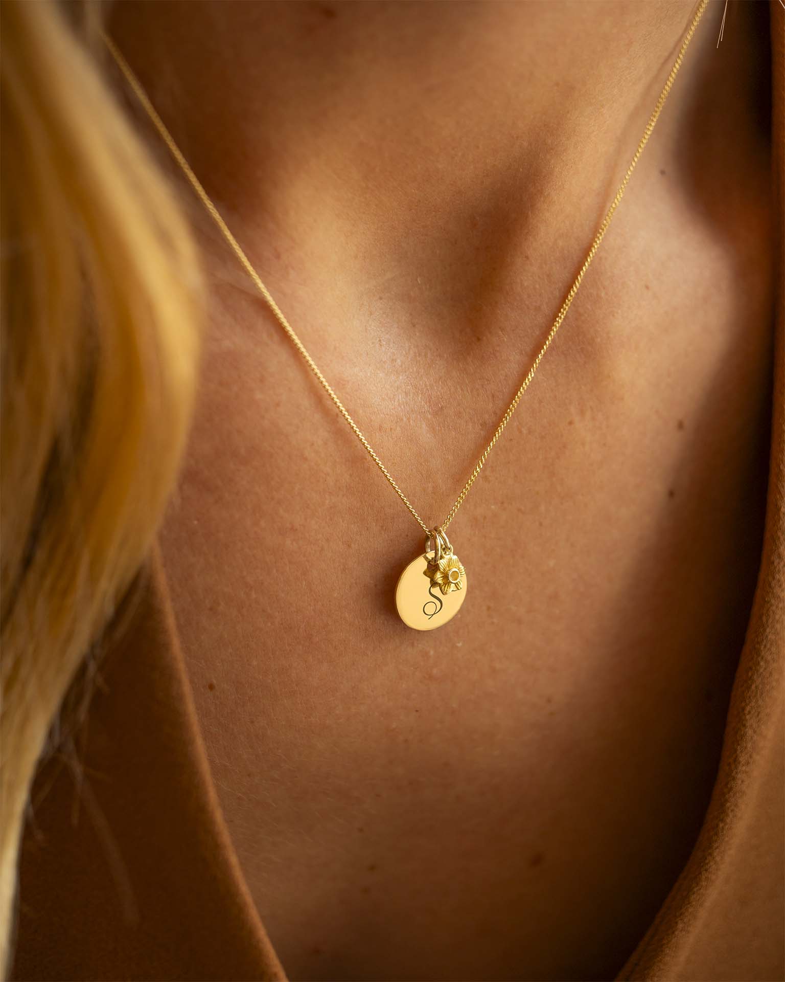 Gold necklace with a pendant on a person's neck. | Christmas