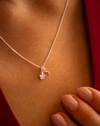 Silver necklace with a heart-shaped pendant worn by a person | Christmas