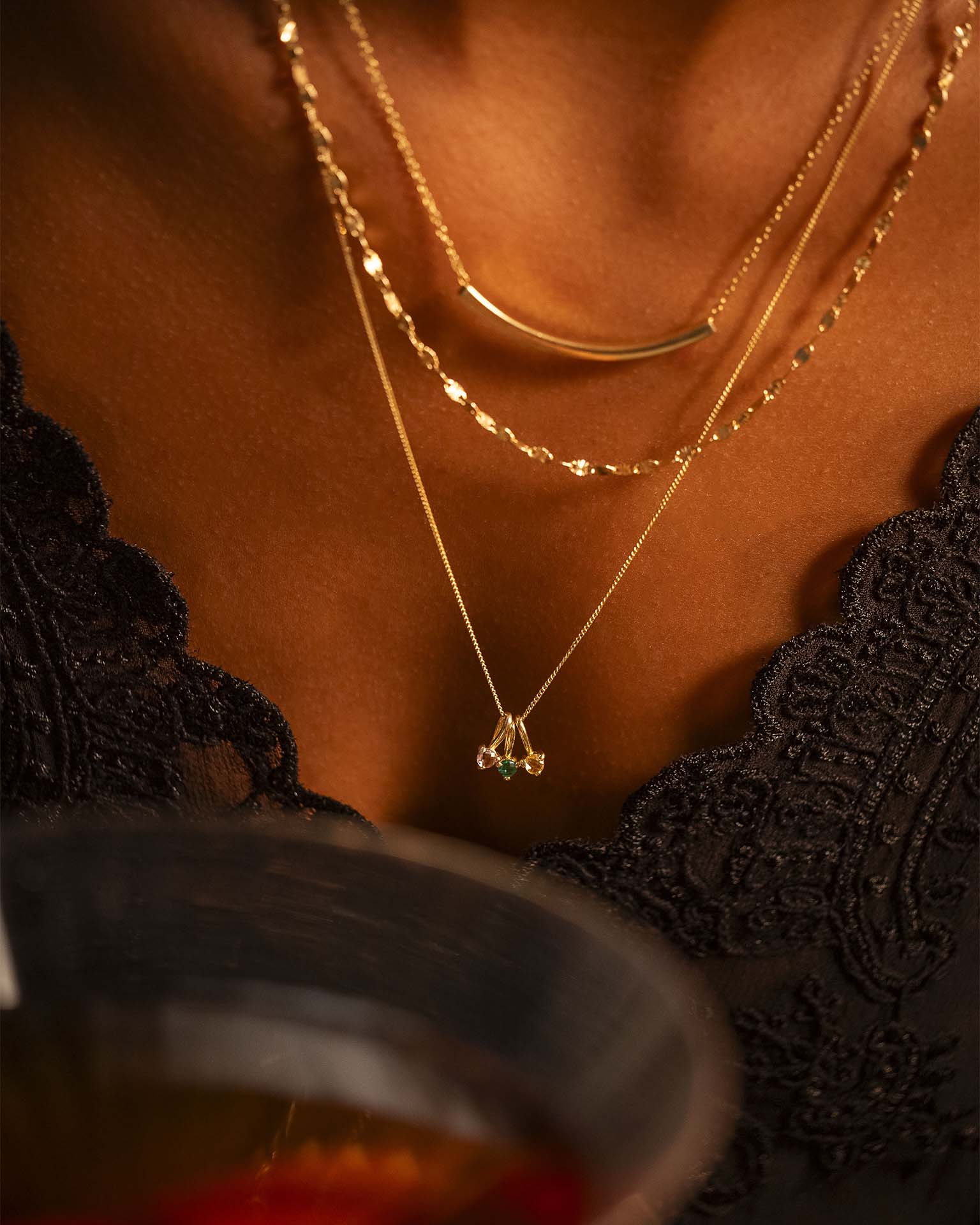 Close-up of a person wearing gold necklaces with a blurred background