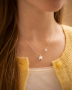 Star-shaped necklace worn by a person with a yellow cardigan | Christmas