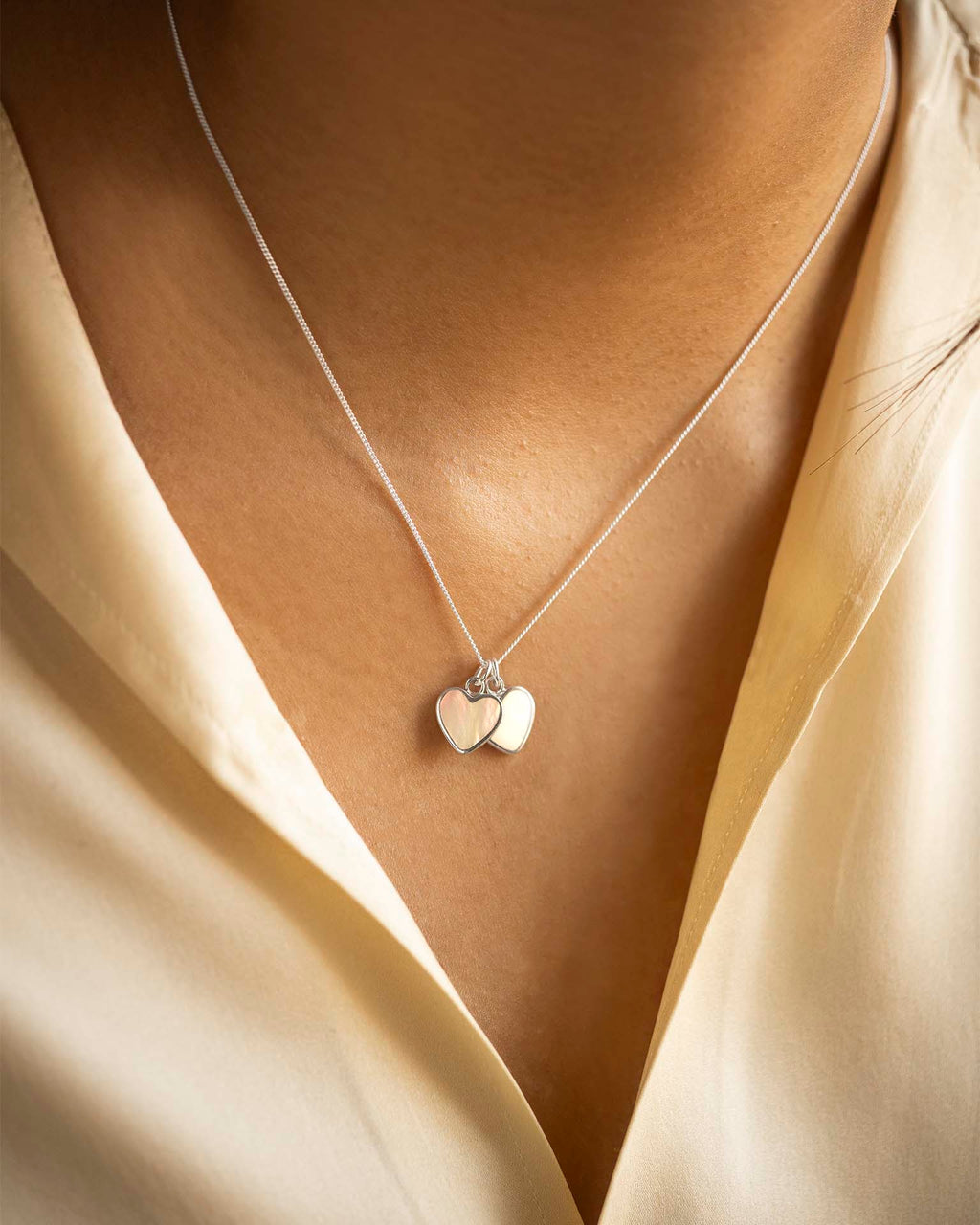 Necklace with heart-shaped pendants on a beige background