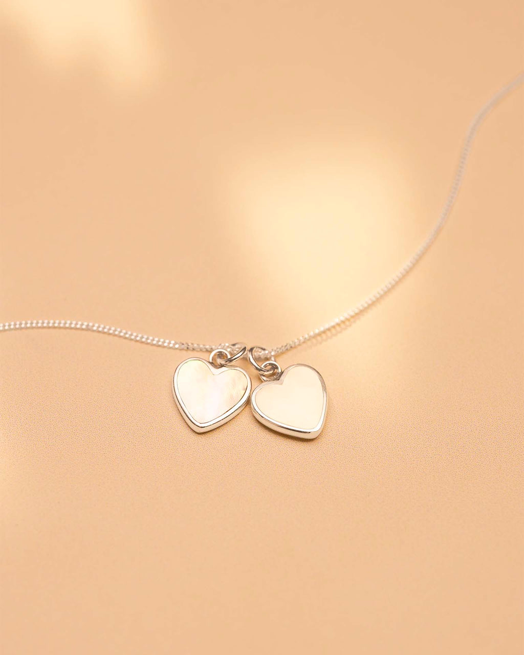 Necklace with heart-shaped pendants on a beige background