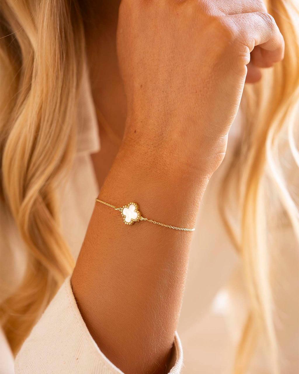 Gold bracelet on a wrist with a blurred background