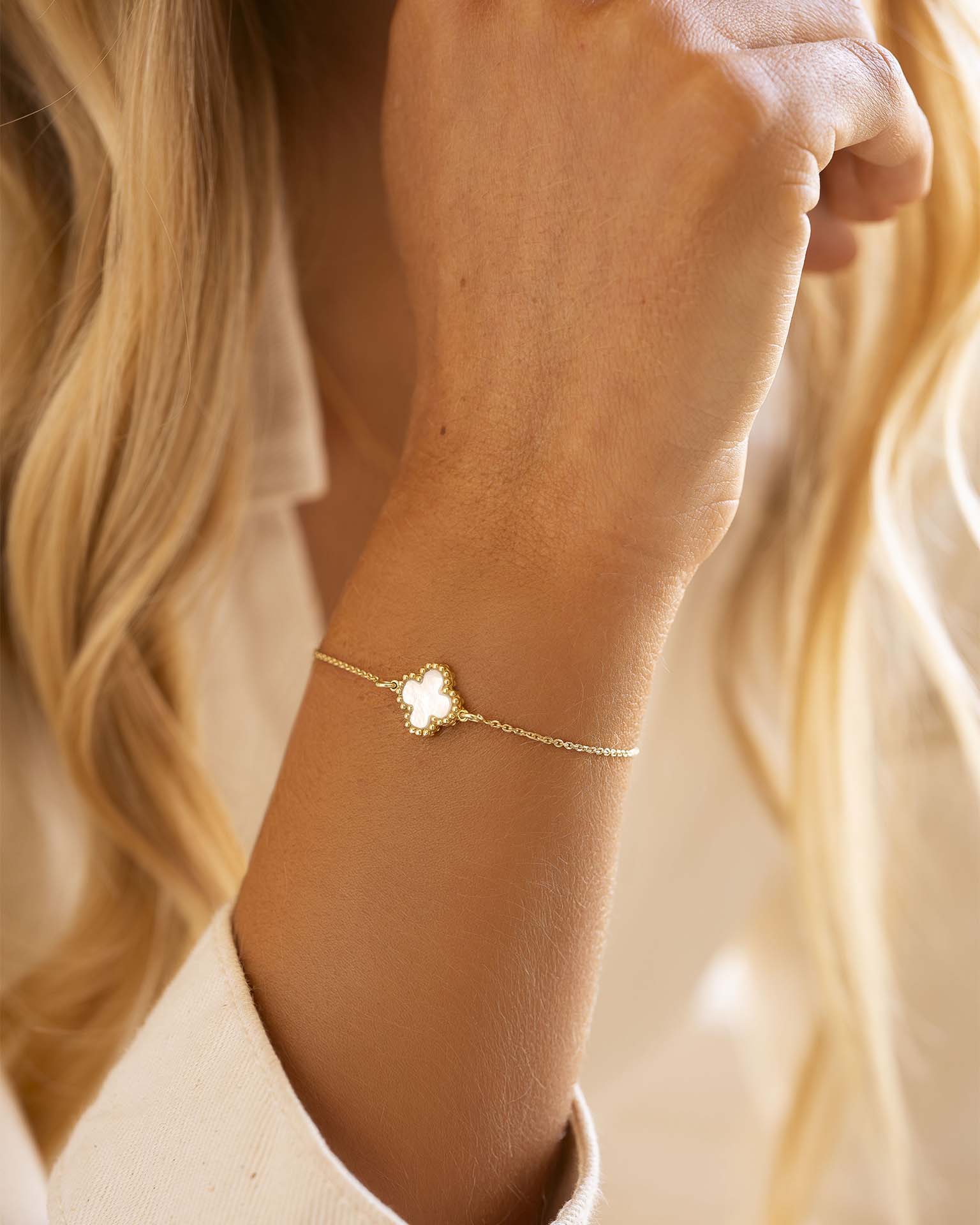 Gold bracelet on a wrist with a blurred background