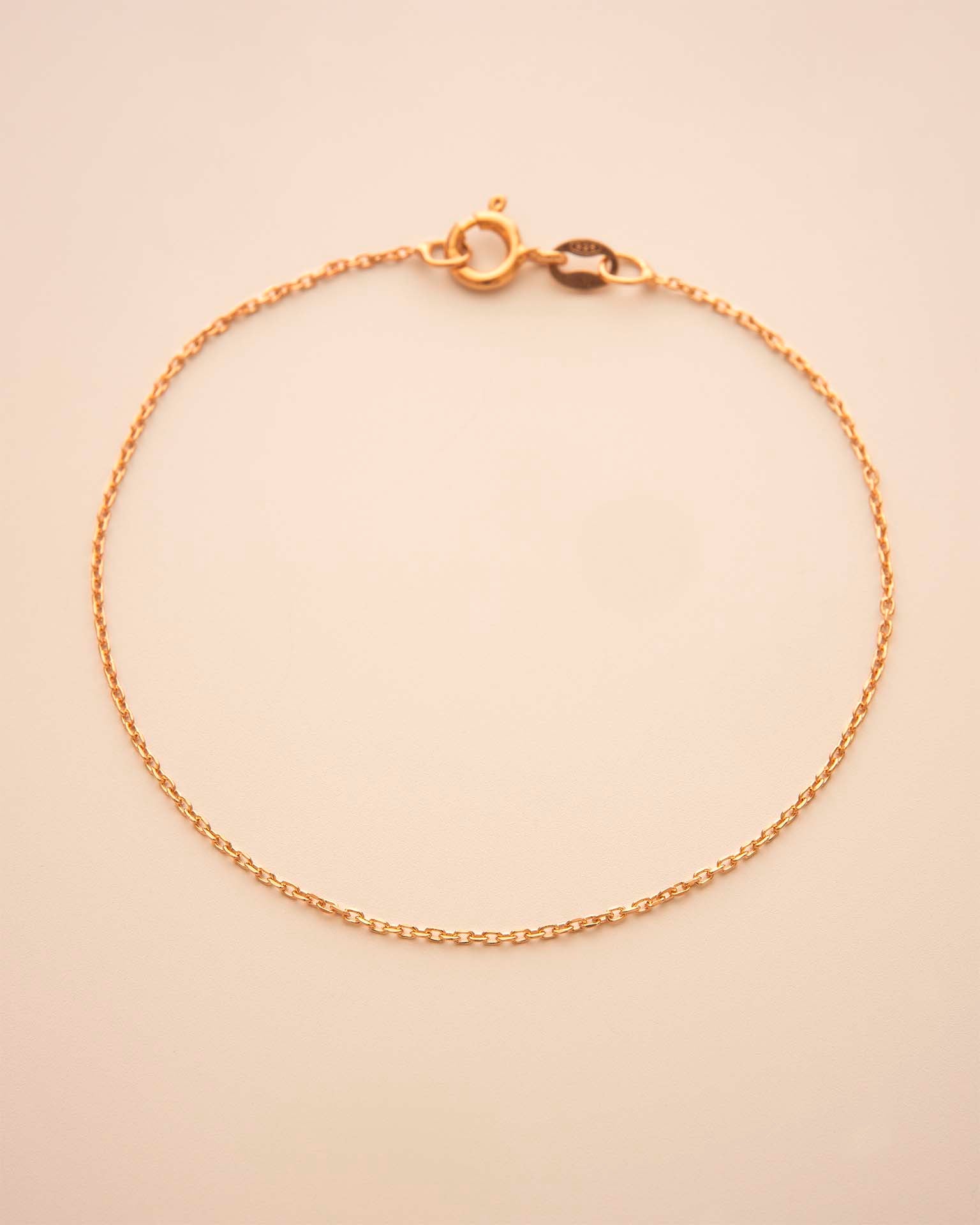 Gold bracelet on a beige background