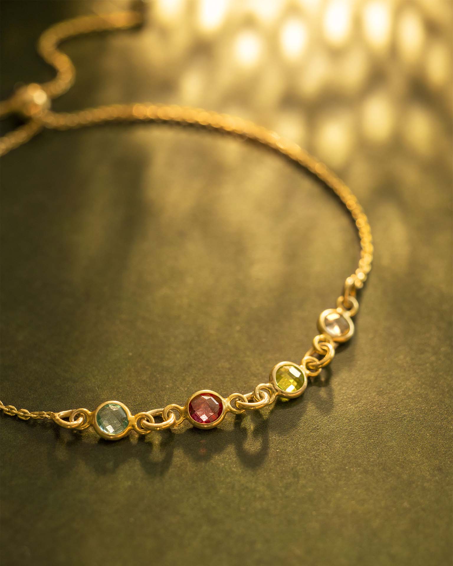 Gold bracelet with embedded gemstones on a dark surface | Christmas