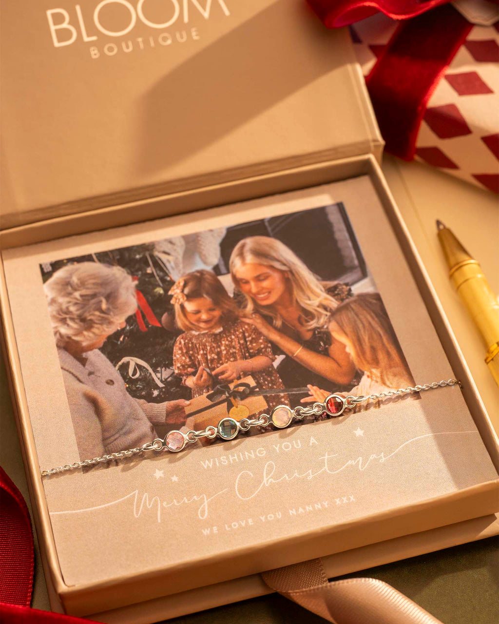 Bracelet with decorative stones in a 'Bloom Boutique' box with a photo of a family.