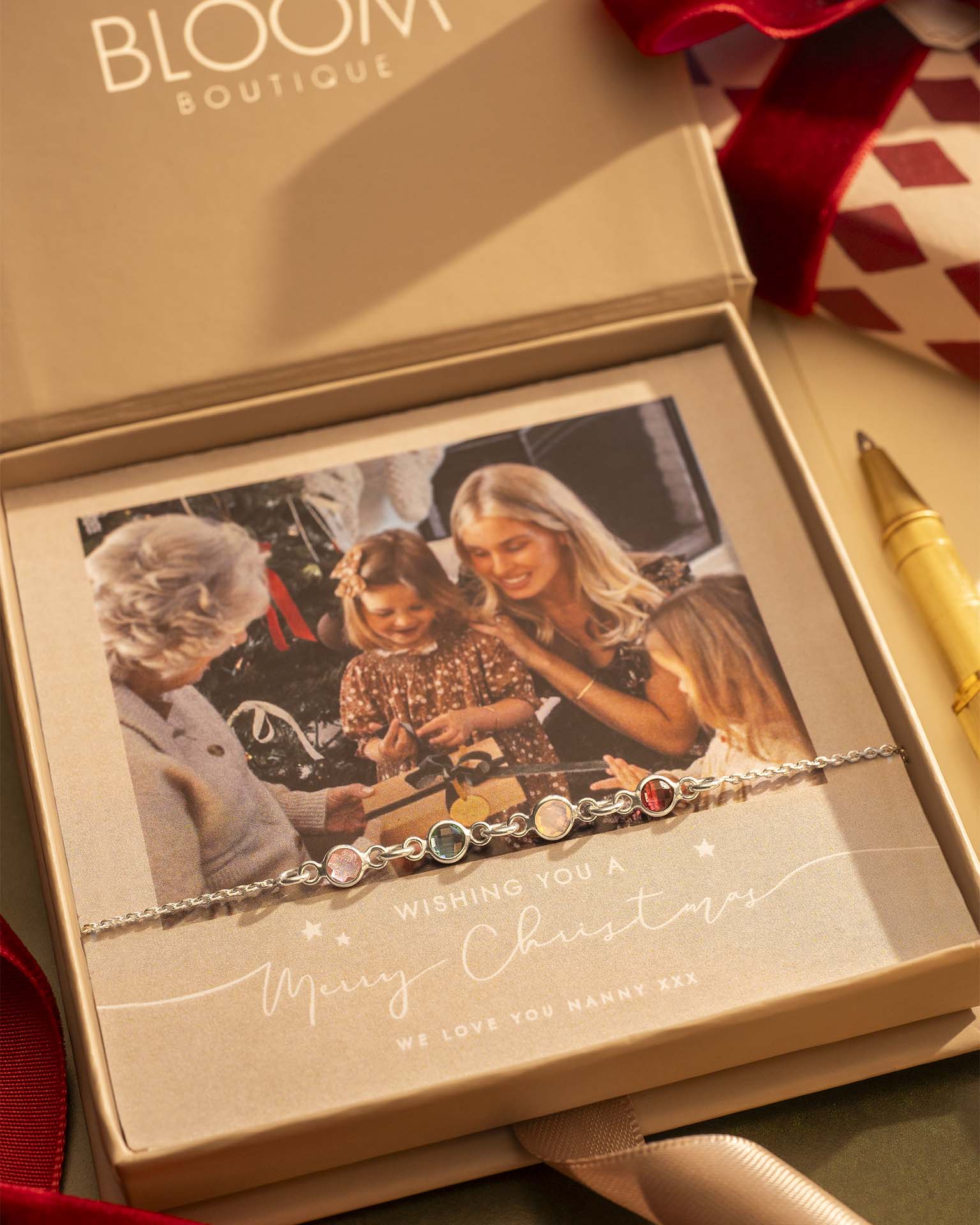 Bracelet with decorative stones in a 'Bloom Boutique' box with a photo of a family.