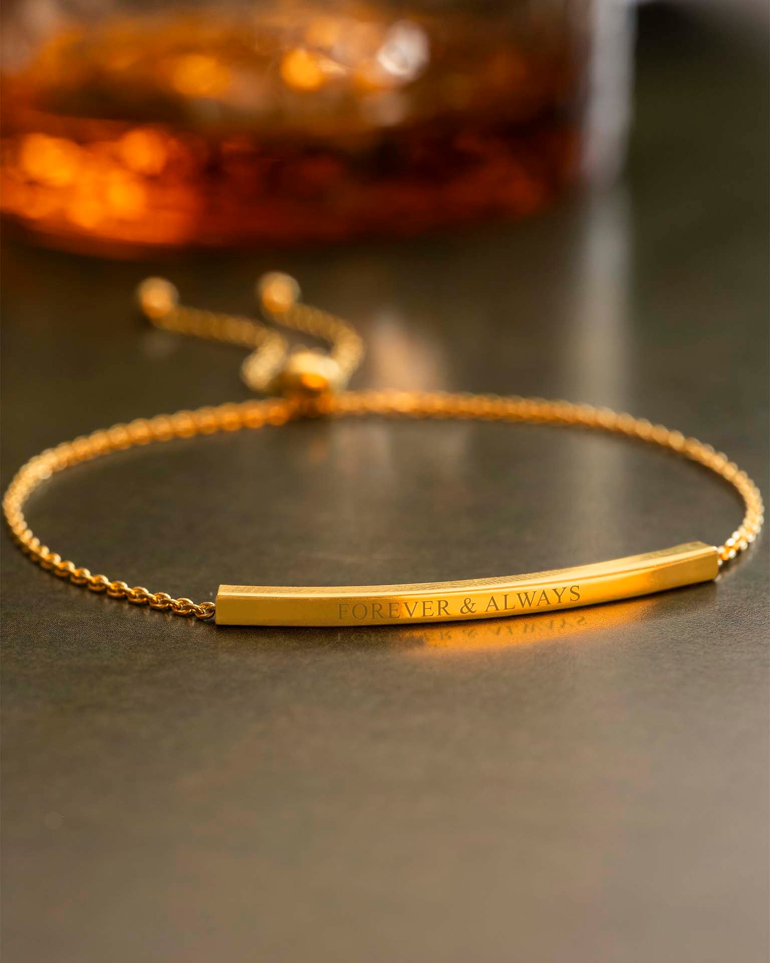 Gold bracelet with 'Forever & Always' engraving on a dark surface | Christmas