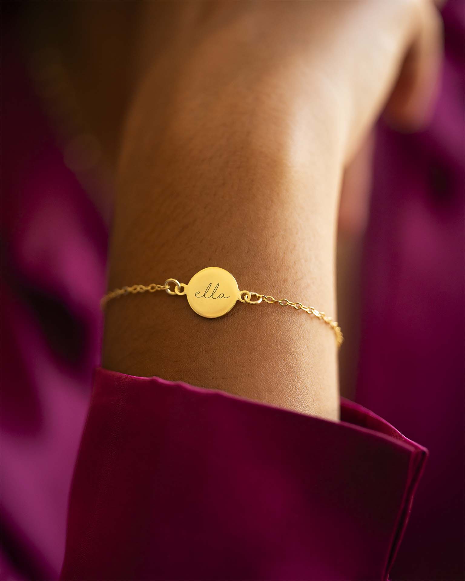 Gold bracelet with a name on it worn on a wrist against a blurred background | Christmas