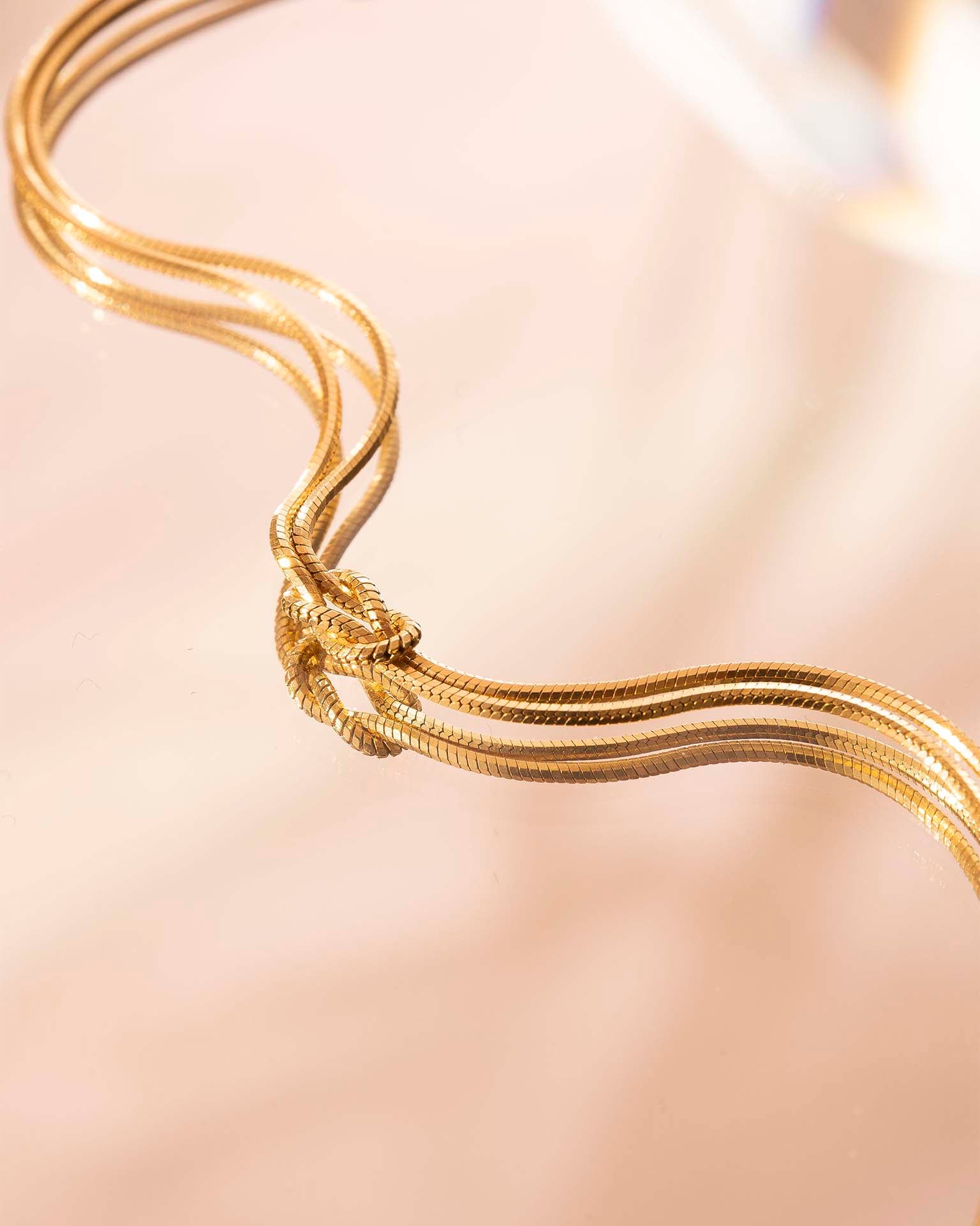 Gold necklace on a soft beige background