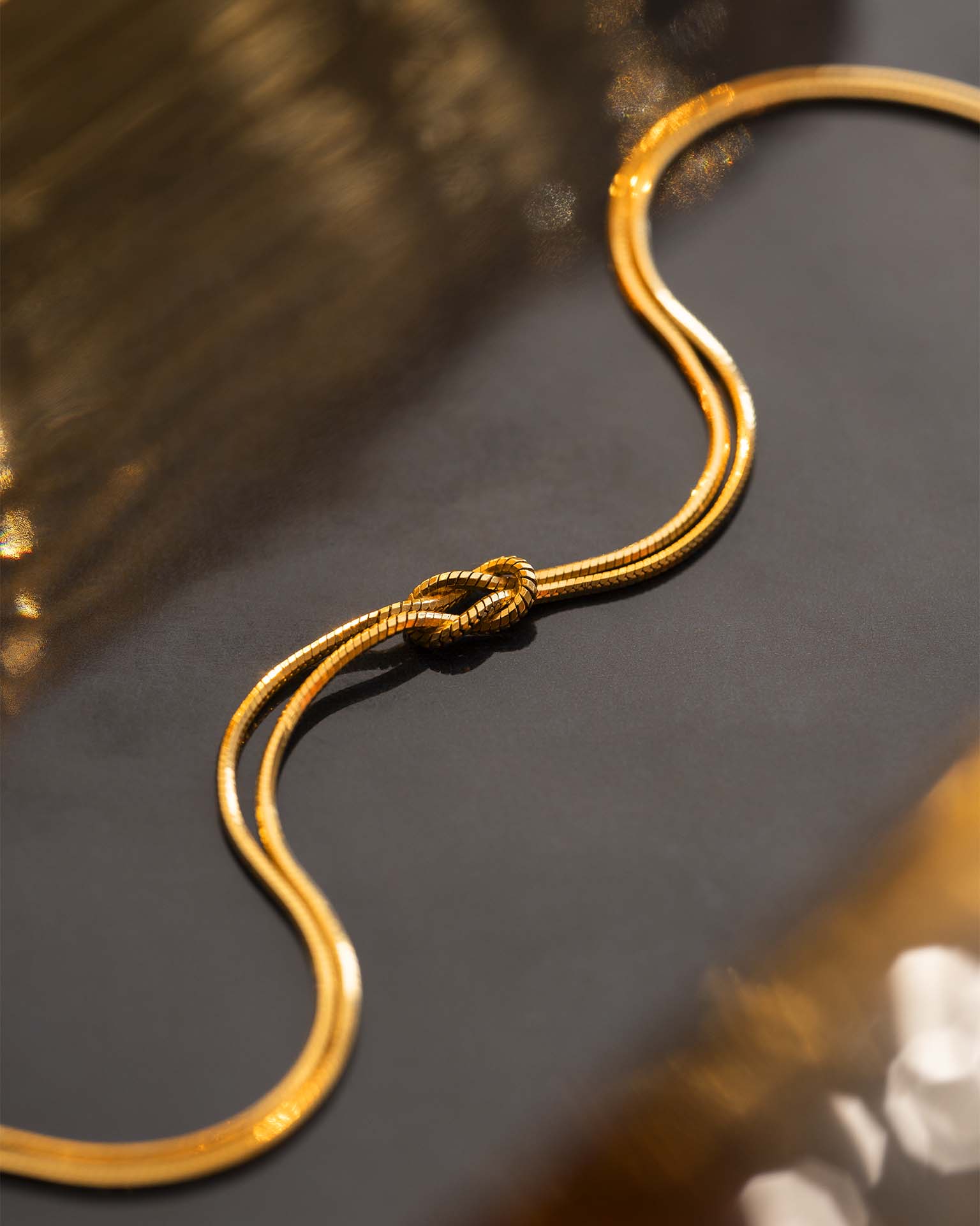 Gold necklace on a reflective surface