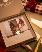 Bracelet with a heart charm in a Bloom Boutique box with a photo of two people.