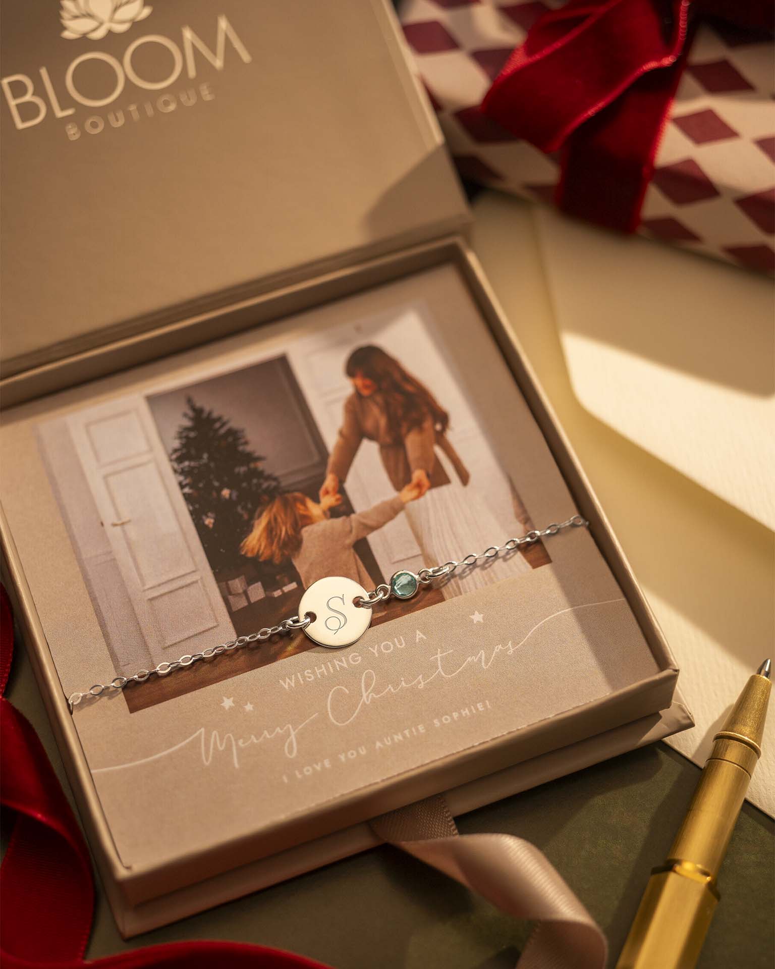 Bracelet with a heart charm in a Bloom Boutique box with a photo of two people.