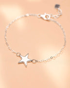 Silver star bracelet on a beige background
