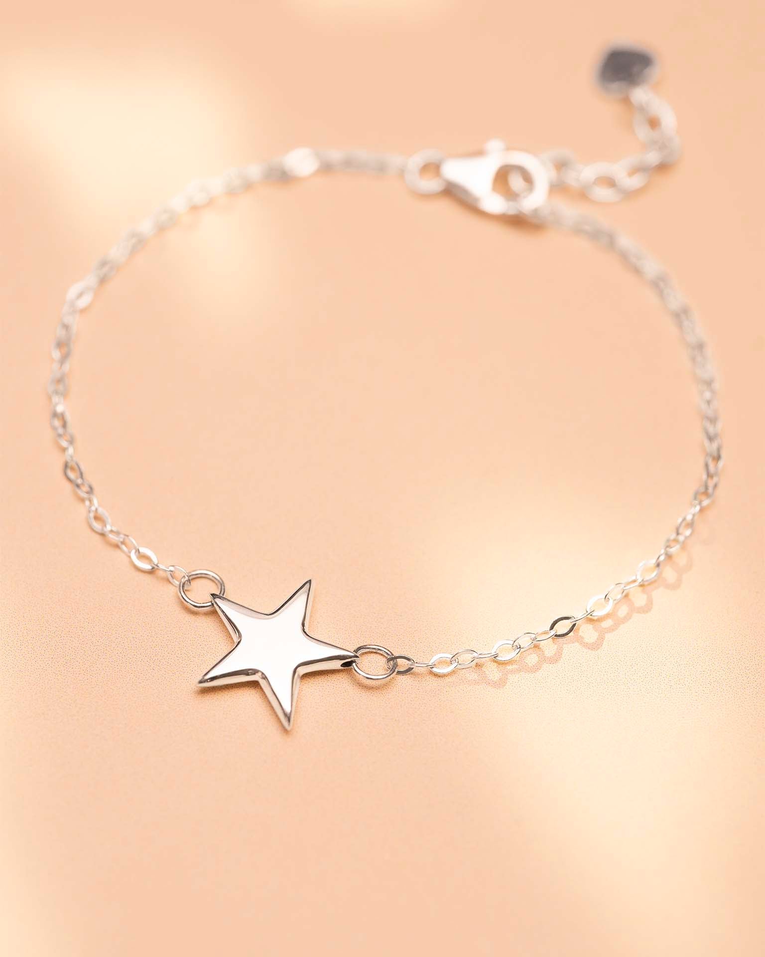 Silver star bracelet on a beige background
