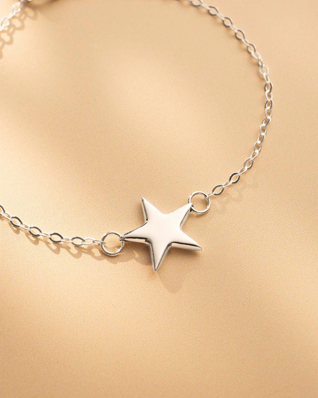 Silver star bracelet on a gold background