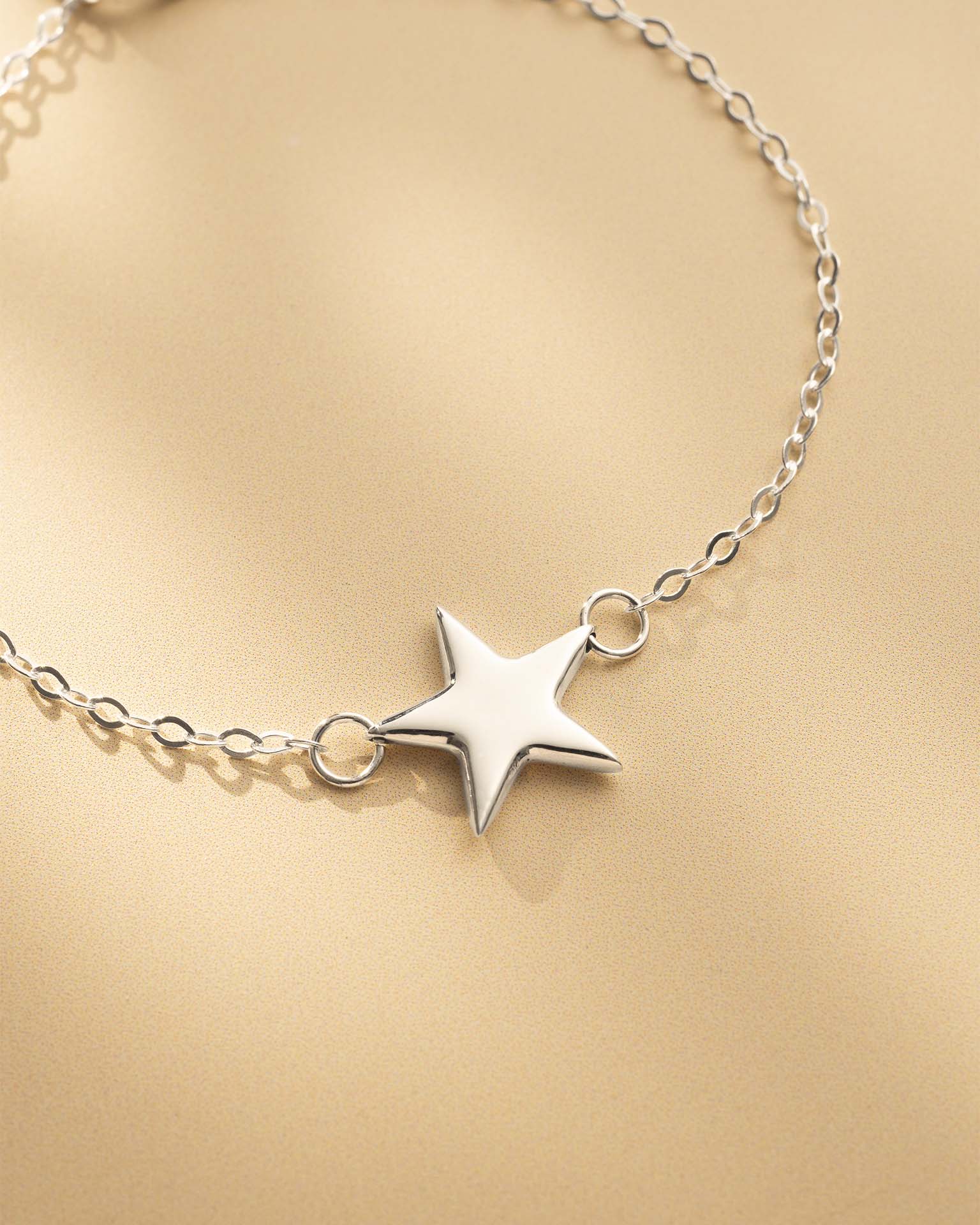 Silver star bracelet on a gold background