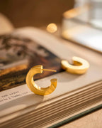 Gold hoop earrings on a book