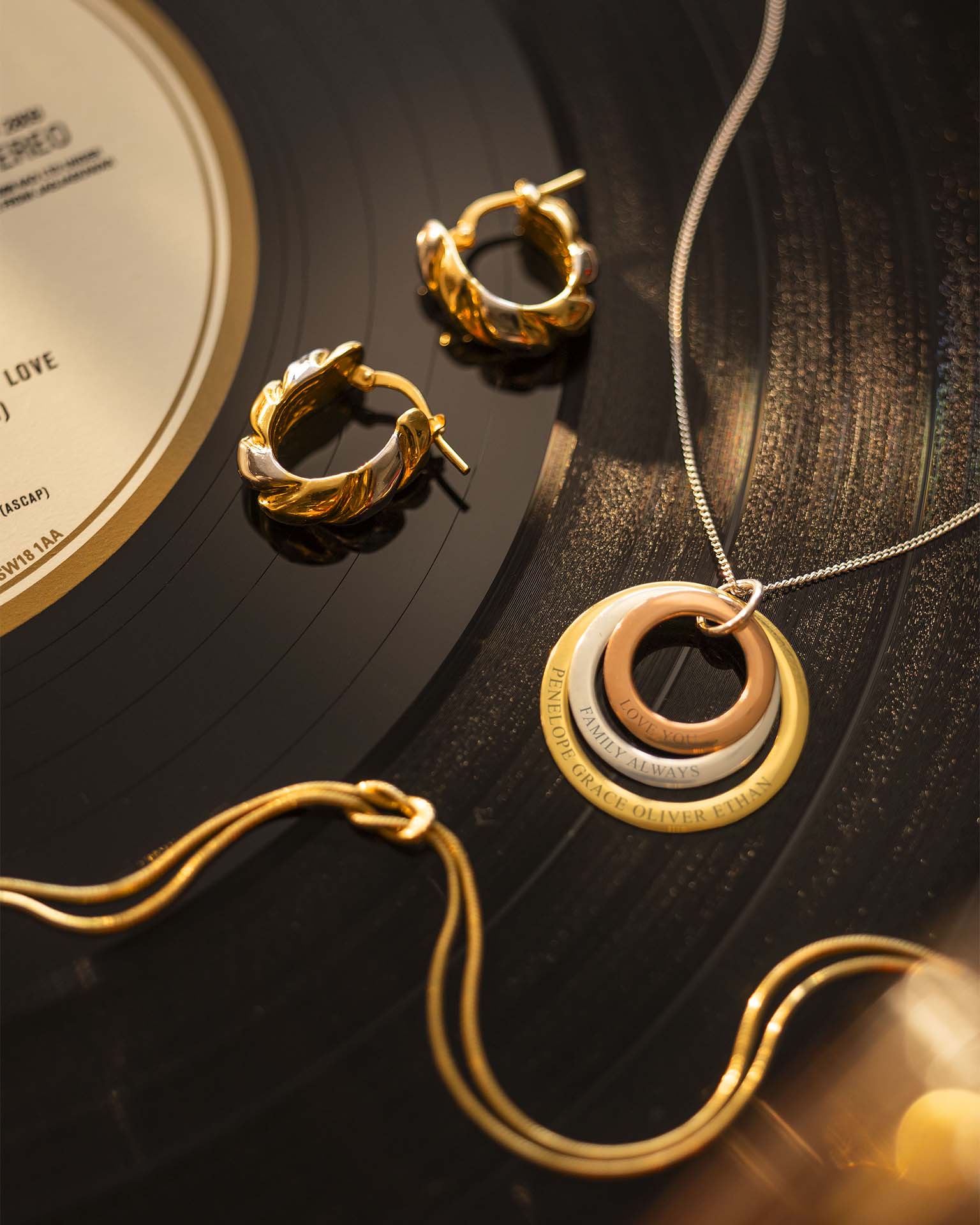 Gold jewelry including earrings and a necklace on a vinyl record
