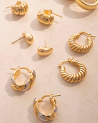 Gold earrings on a light background