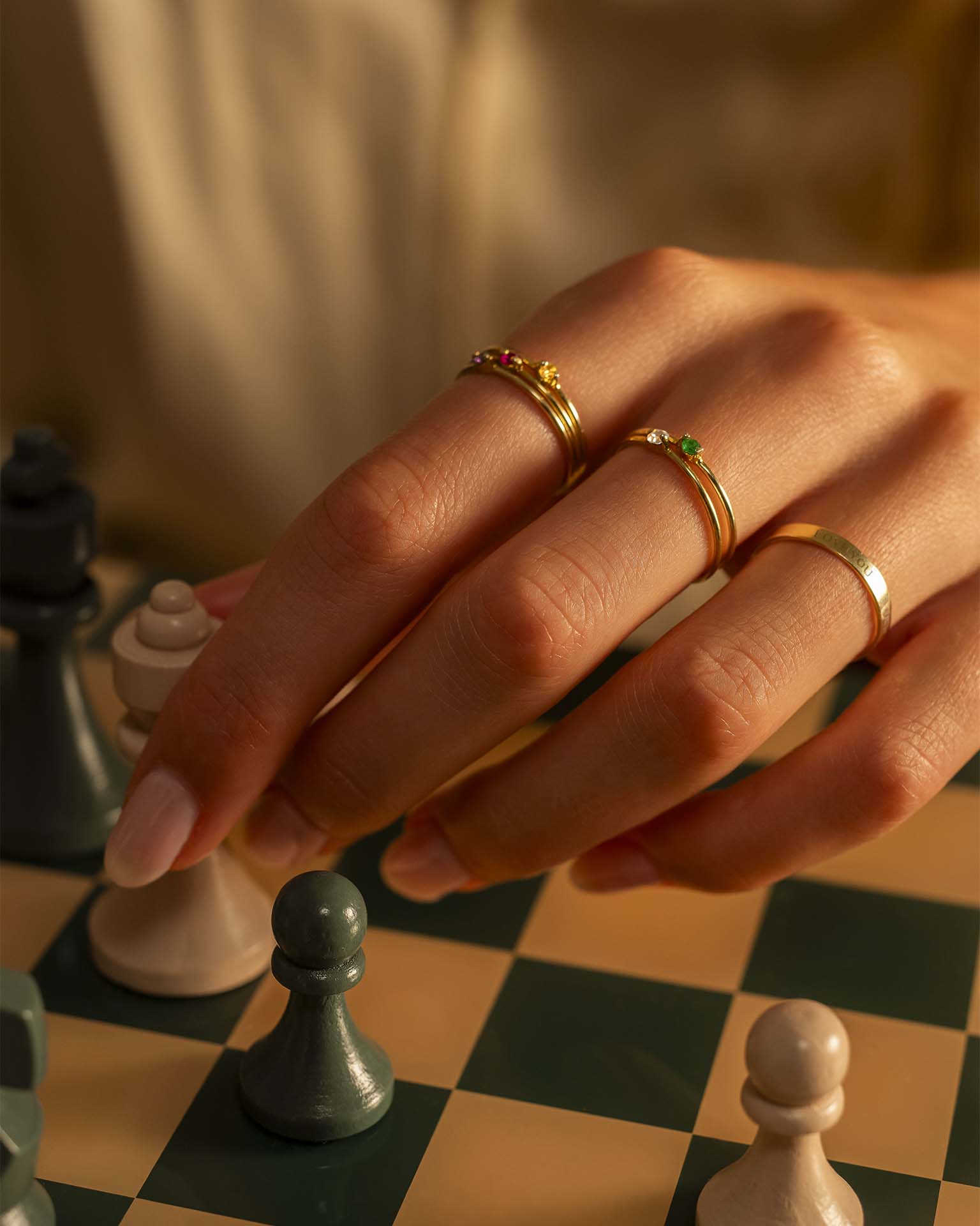 Hand with gold rings holding chess piece | Christmas